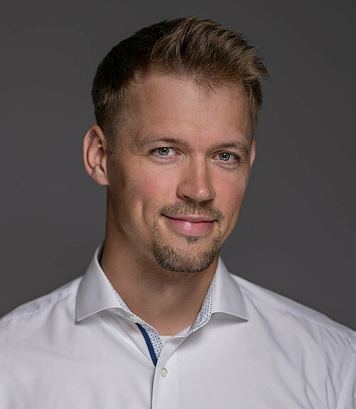 Portraitfoto eines BIT Ingenieurs vor einem farbigen Hintergrund.